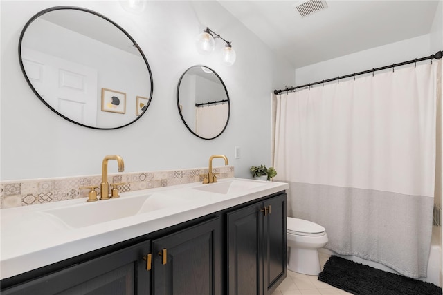 full bath with a sink, toilet, visible vents, double vanity, and tile patterned flooring