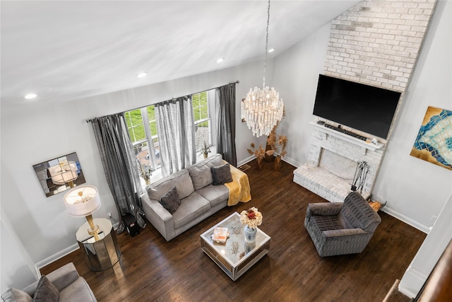 living area with a brick fireplace, a notable chandelier, wood finished floors, and baseboards