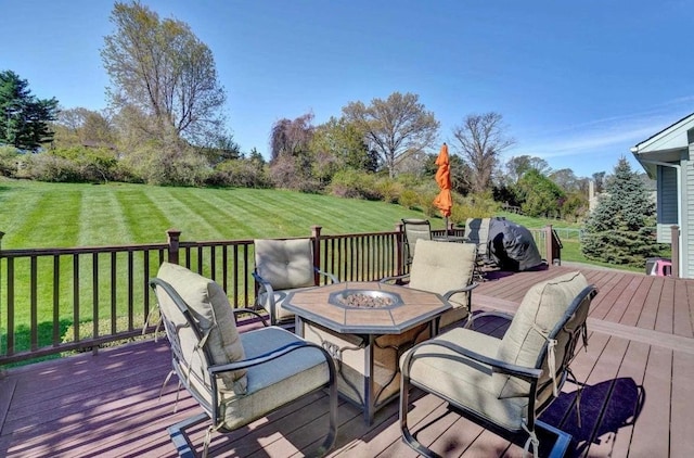 wooden deck featuring a lawn and an outdoor fire pit