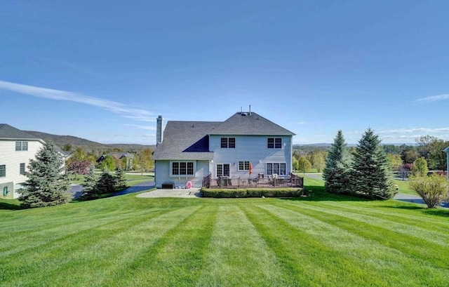 back of house with a yard, a patio area, and a chimney