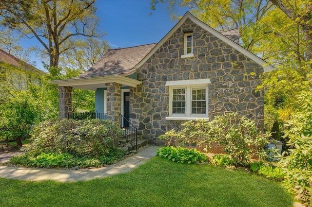 view of front of home featuring stone siding and a front yard