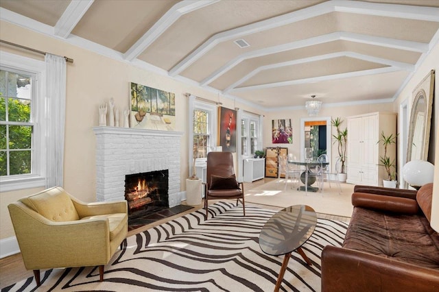 living area with a brick fireplace, visible vents, a healthy amount of sunlight, and vaulted ceiling with beams