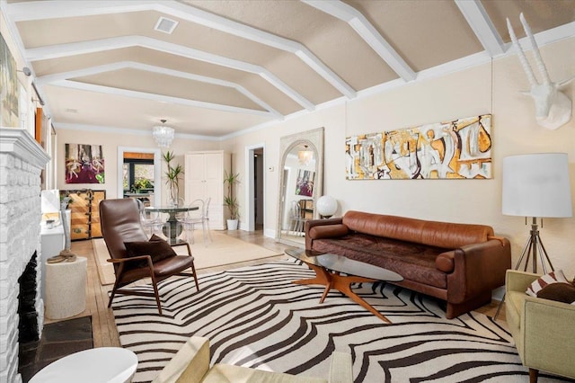 living area with visible vents, wood finished floors, lofted ceiling, and a brick fireplace