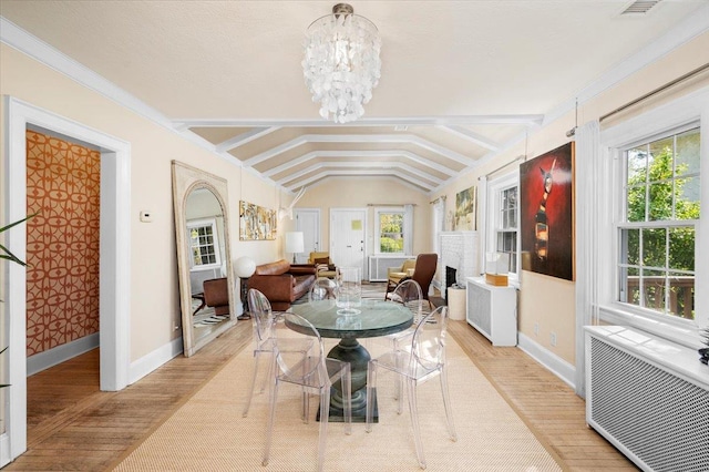 dining area featuring lofted ceiling with beams, baseboards, and wood finished floors