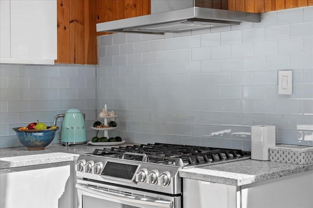 kitchen with white cabinets, gas stove, exhaust hood, and tasteful backsplash
