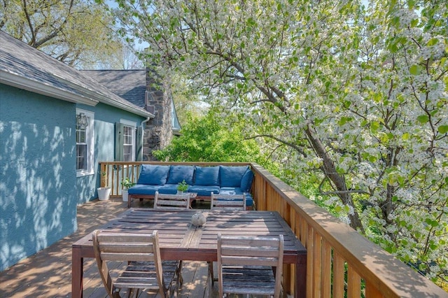wooden terrace with an outdoor hangout area and outdoor dining space