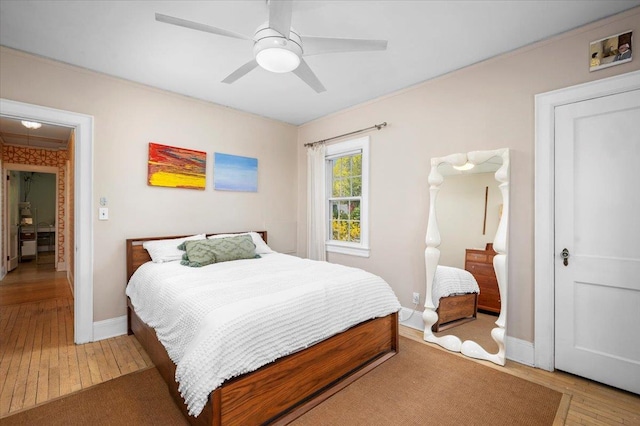 bedroom with baseboards, a ceiling fan, and hardwood / wood-style floors