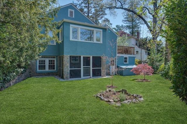 rear view of property with a yard and stucco siding
