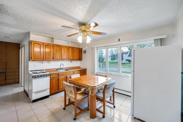 kitchen featuring brown cabinets, a ceiling fan, a baseboard heating unit, and white appliances