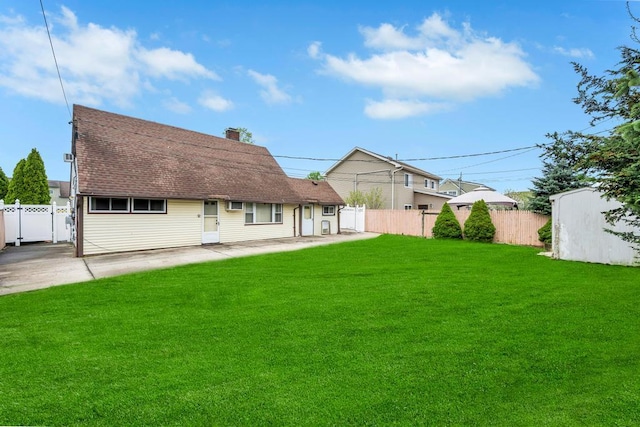 back of house with fence, roof with shingles, a chimney, a patio area, and a lawn