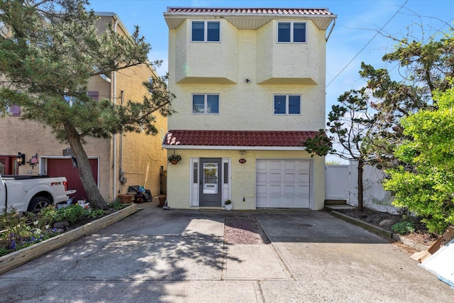 view of front of property featuring a garage, stucco siding, and a tile roof