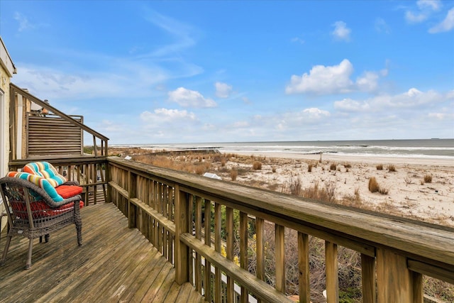 wooden terrace with a view of the beach and a water view