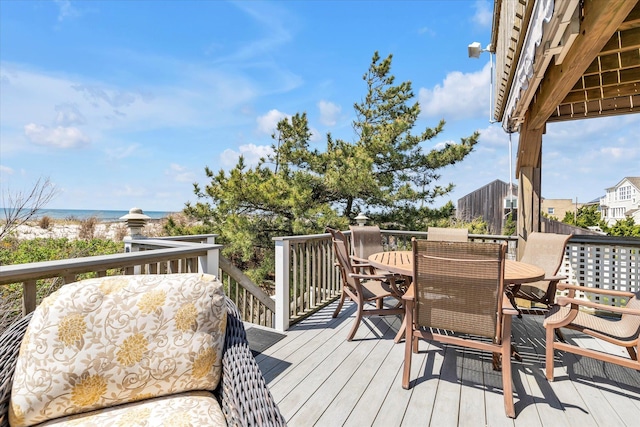 wooden deck with outdoor dining space and a water view