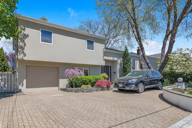 split level home with an attached garage and decorative driveway