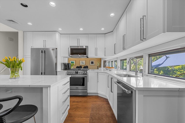 kitchen with high quality appliances, light stone countertops, a sink, recessed lighting, and visible vents
