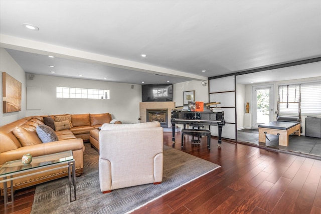 living area featuring recessed lighting, a glass covered fireplace, and wood finished floors
