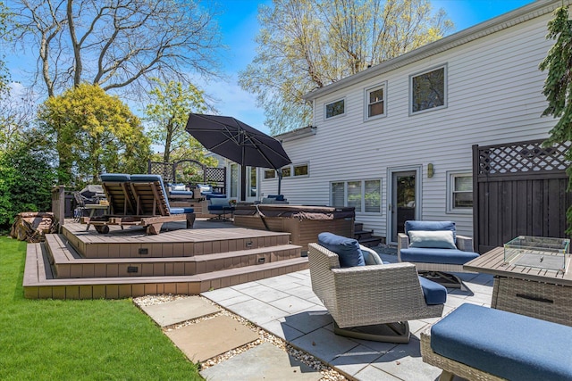 view of patio featuring fence, a covered hot tub, a wooden deck, and outdoor lounge area
