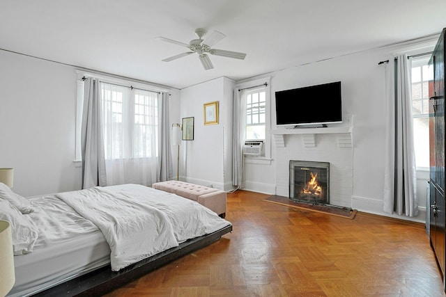 bedroom featuring a fireplace, cooling unit, baseboards, and ceiling fan
