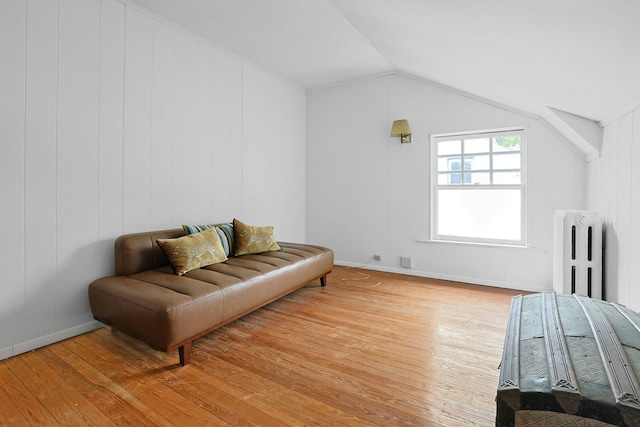 sitting room featuring radiator, hardwood / wood-style floors, and lofted ceiling