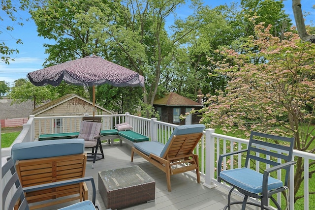 wooden terrace featuring an outdoor hangout area and an outbuilding