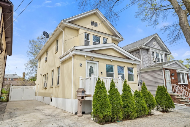 view of front of property with fence, driveway, a gate, and stucco siding