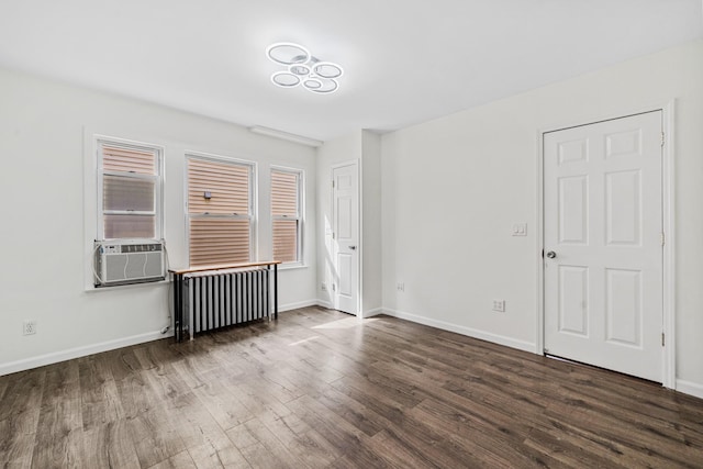 unfurnished room with baseboards, radiator, wood finished floors, and cooling unit