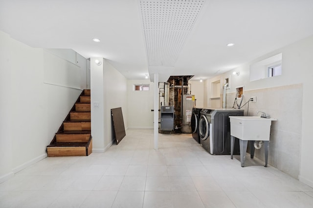 laundry room with gas water heater, laundry area, a sink, separate washer and dryer, and recessed lighting