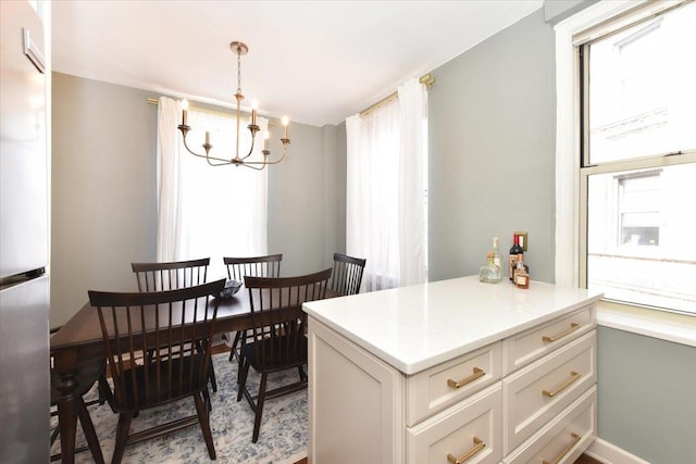 8 Barstow Rd Unit 6-D, Great Neck, NY 11021 - dining area featuring an inviting chandelier, baseboards, and a wealth of natural light