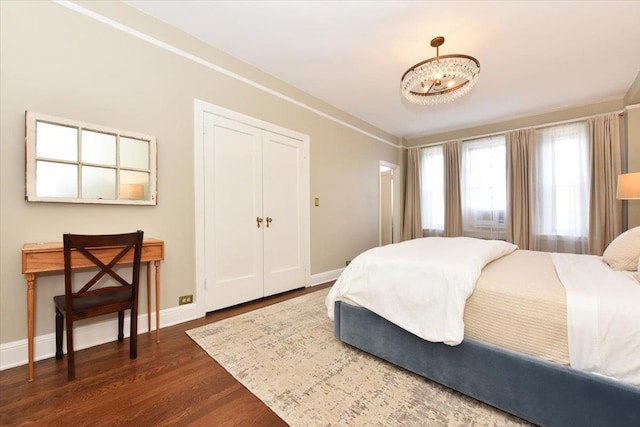 8 Barstow Rd Unit 6-D, Great Neck, NY 11021 - bedroom with baseboards, a notable chandelier, and dark wood-type flooring
