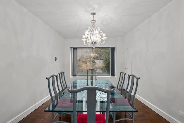 dining room with a chandelier and baseboards