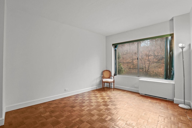 unfurnished room featuring radiator heating unit and baseboards