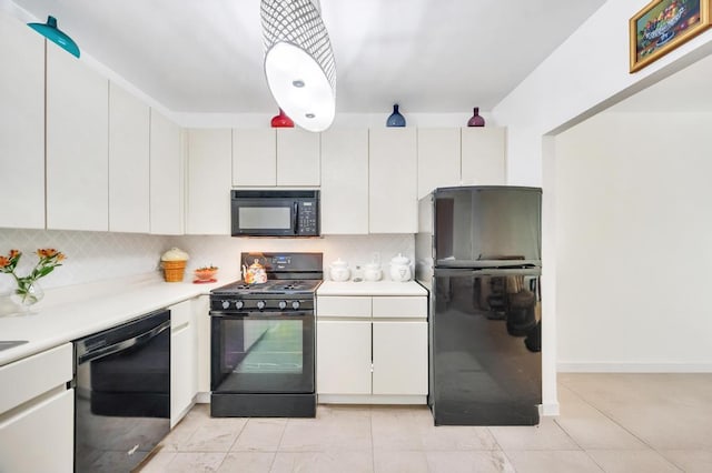 kitchen with decorative backsplash, light countertops, white cabinets, black appliances, and light tile patterned flooring