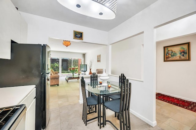 dining space featuring baseboards and light tile patterned floors