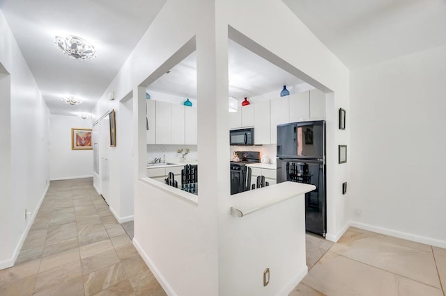 kitchen featuring a sink, black appliances, white cabinetry, and marble finish floor