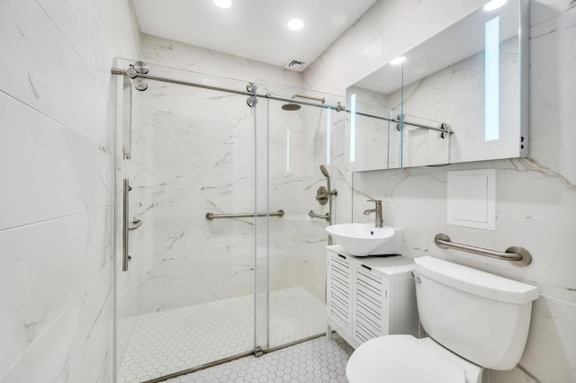 full bath featuring visible vents, tile walls, vanity, toilet, and a marble finish shower