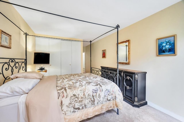 carpeted bedroom featuring baseboards and a closet