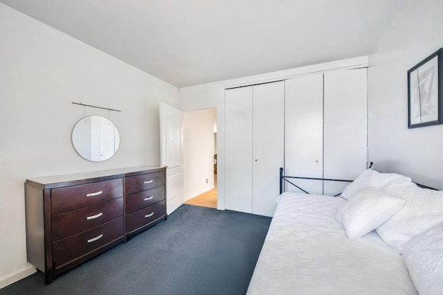 bedroom with a closet and dark carpet
