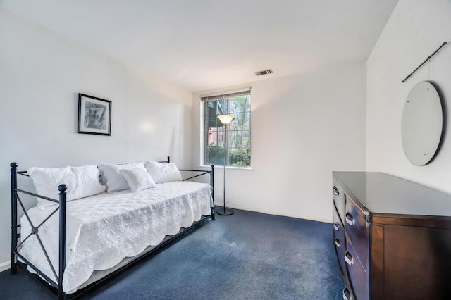 bedroom with visible vents and dark carpet