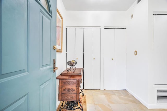 foyer entrance featuring baseboards and visible vents