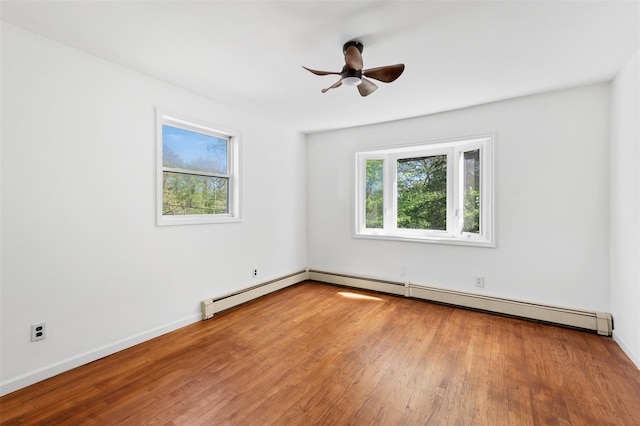 spare room with baseboards, ceiling fan, and wood finished floors