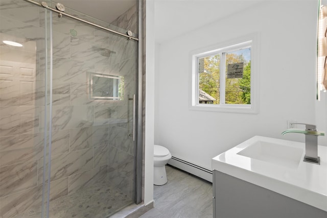 bathroom with vanity, baseboard heating, a stall shower, and toilet