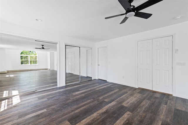 unfurnished bedroom with multiple closets, wood finished floors, baseboards, ceiling fan, and a baseboard radiator