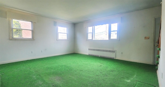 empty room featuring radiator, carpet, and baseboards