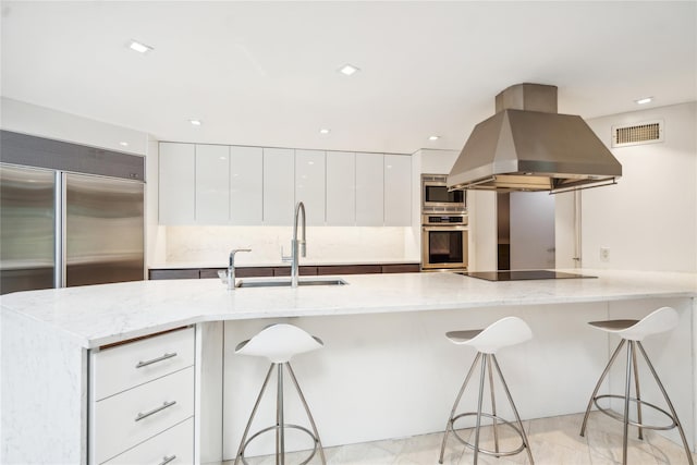 80 Valentines Ln, Old Brookville, NY 11545 - kitchen featuring island exhaust hood, built in appliances, modern cabinets, a sink, and white cabinetry