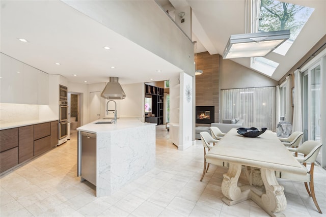 80 Valentines Ln, Old Brookville, NY 11545 - kitchen featuring modern cabinets, a center island with sink, light countertops, white cabinets, and a towering ceiling
