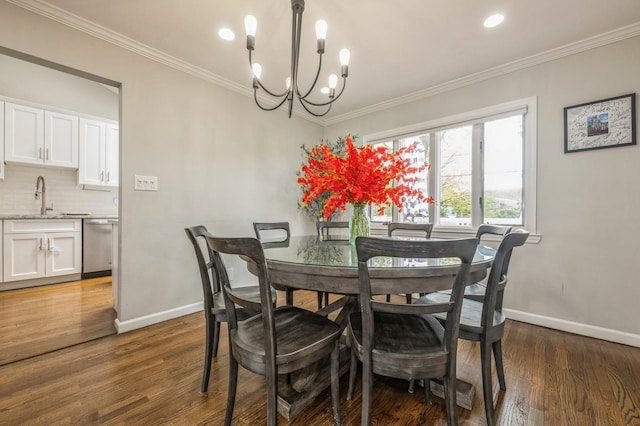dining room featuring baseboards, a chandelier, ornamental molding, and wood finished floors