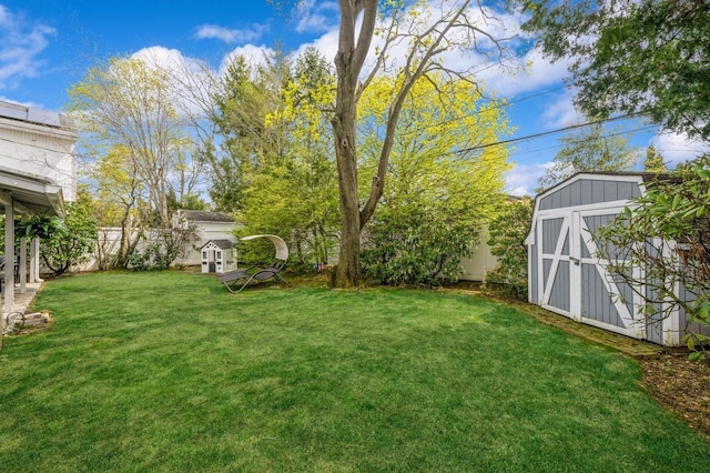 view of yard featuring an outdoor structure, a shed, and a fenced backyard