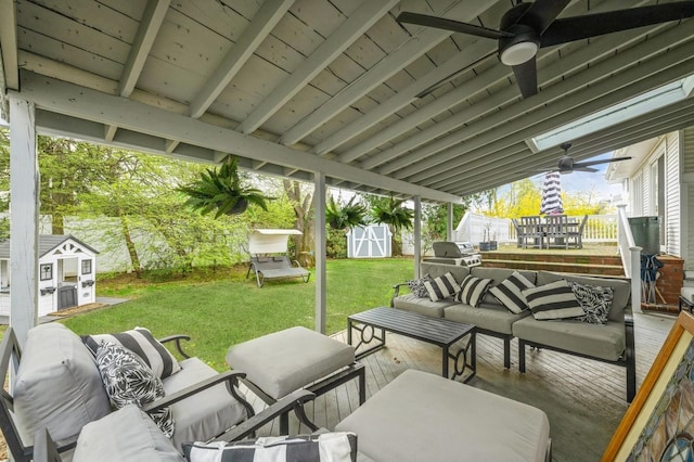 view of patio with outdoor lounge area, a shed, a fenced backyard, a ceiling fan, and an outdoor structure