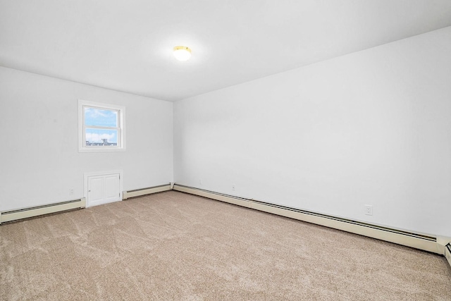 spare room with baseboards, baseboard heating, and carpet