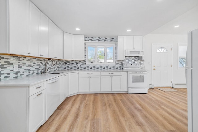 kitchen with a sink, white appliances, light countertops, light wood-style flooring, and a baseboard radiator